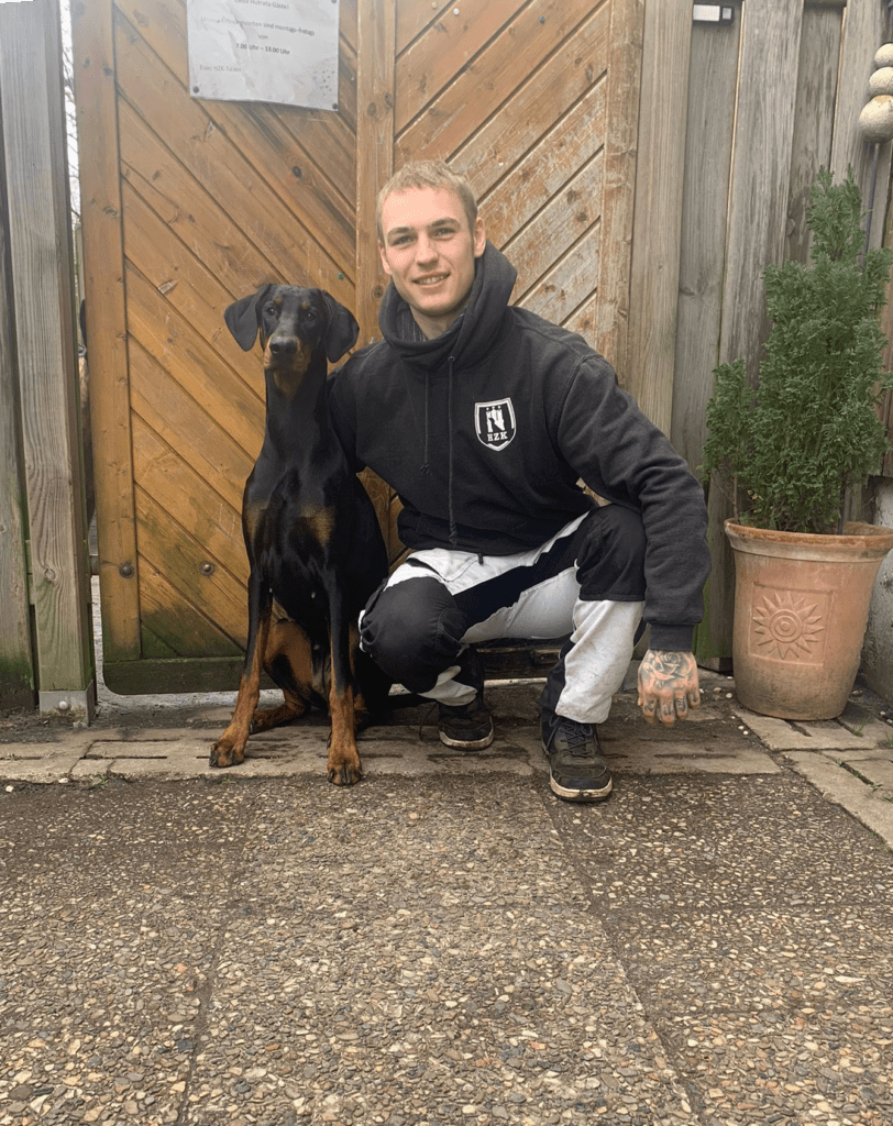 Auszubildender Leif mit seinem Hund vor dem Hundeschulzentrum
